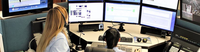 MedCom 911 dispatch operators at multi-screen console